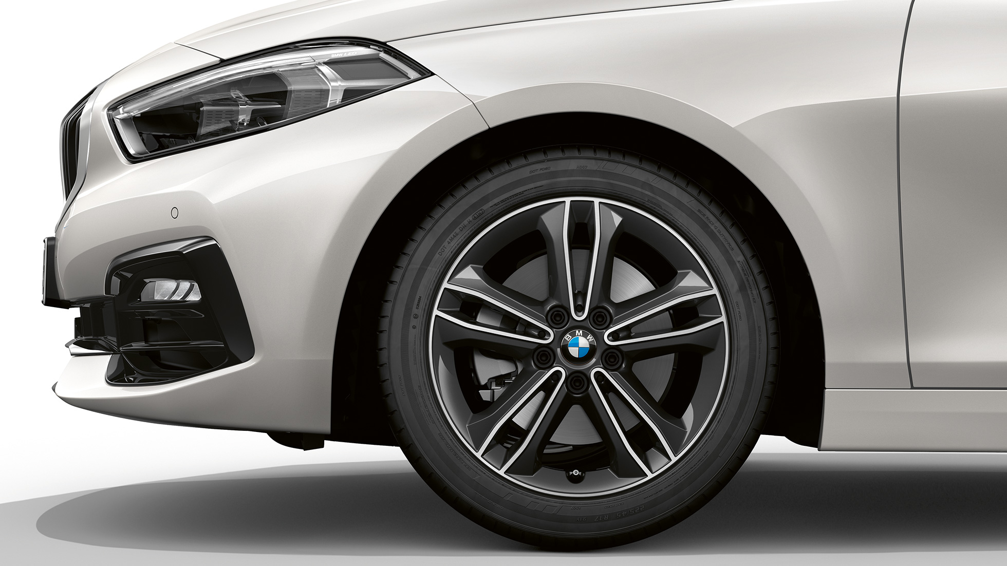 17 inch lichtmetalen wielen in dubbelspaakdesign 549. BMW 1 Serie model Sport Line in Mineralweiß metallic, zijaanzicht van front, met 17 inch lichtmetalen wielen in dubbelspaakdesign 549.
