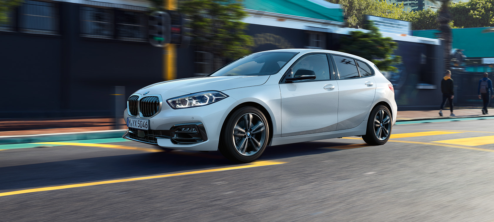 BMW 1 Serie model Sport Line, driekwart zijaanzicht. BMW 1 Serie model Sport Line in Mineralweiß metallic, driekwart zijaanzicht, rijdend.