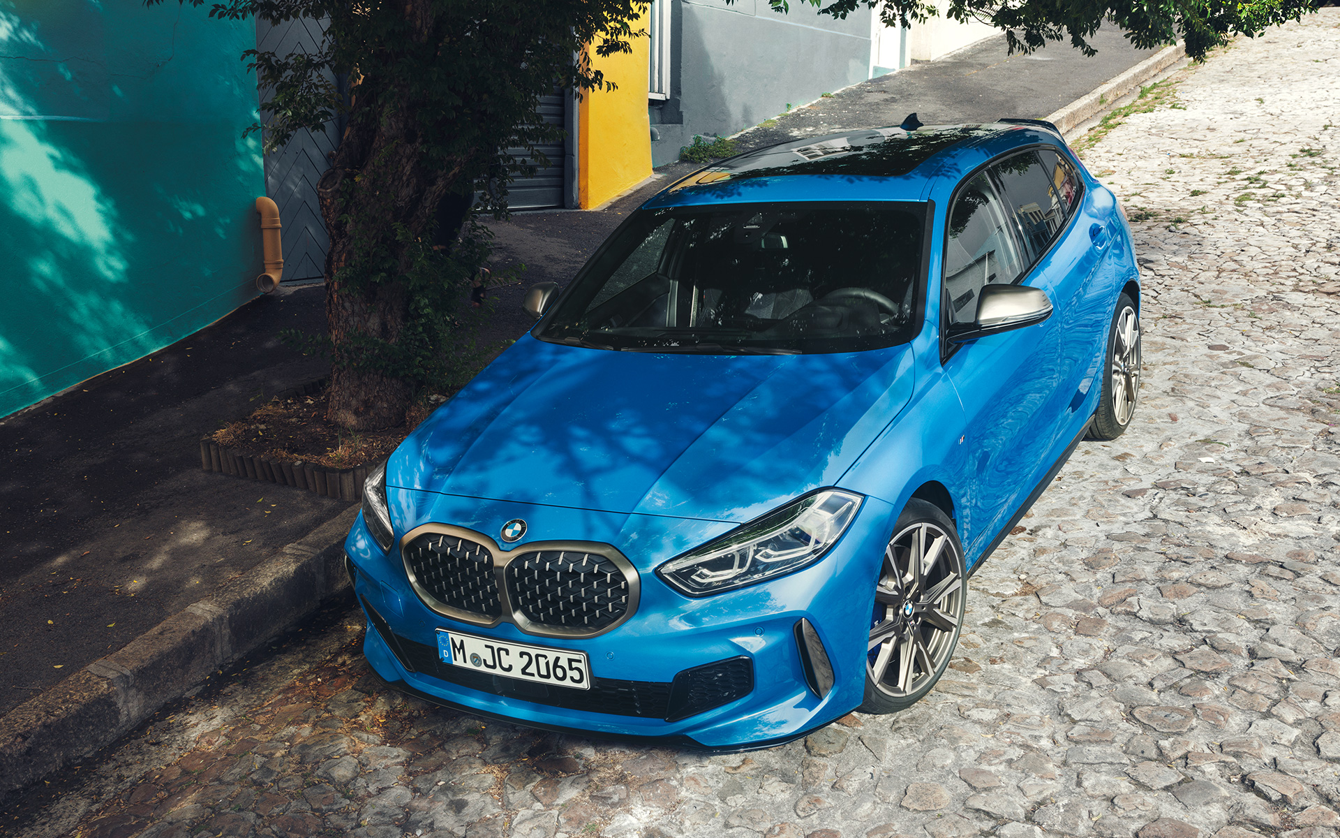 BMW 1 Serie M135i F40 langs straat BMW 1 Serie M135i F40 in Misano Blau metallic driekwart vooraanzicht parkeren bovenaanzicht