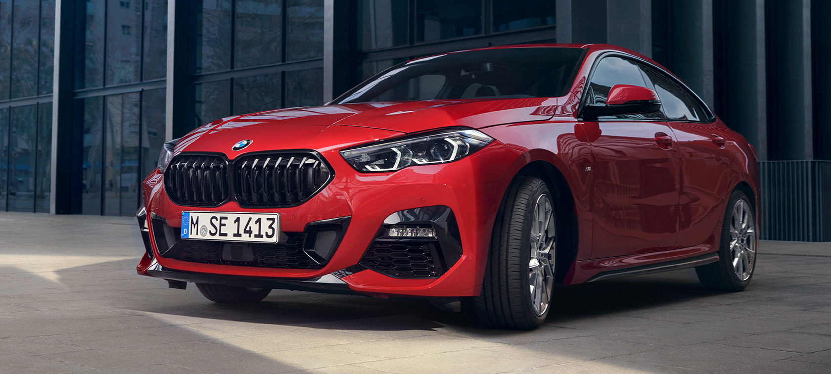 BMW 2 Serie Gran Coupé F44 M135i Driekwart vooraanzicht Edition ColorVision Melbourne Rot metallic BMW 2 Serie Gran Coupé F44 M135i Driekwart vooraanzicht Edition ColorVision Melbourne Rot metallic voor gebouw