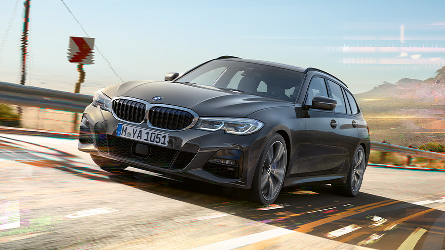 BMW 3 Serie Touring (G21), Dravitgrau, driekwart vooraanzicht BMW 3 Serie Touring (G21) Dravitgrau, driekwart vooraanzicht, rijdend in landelijke omgeving