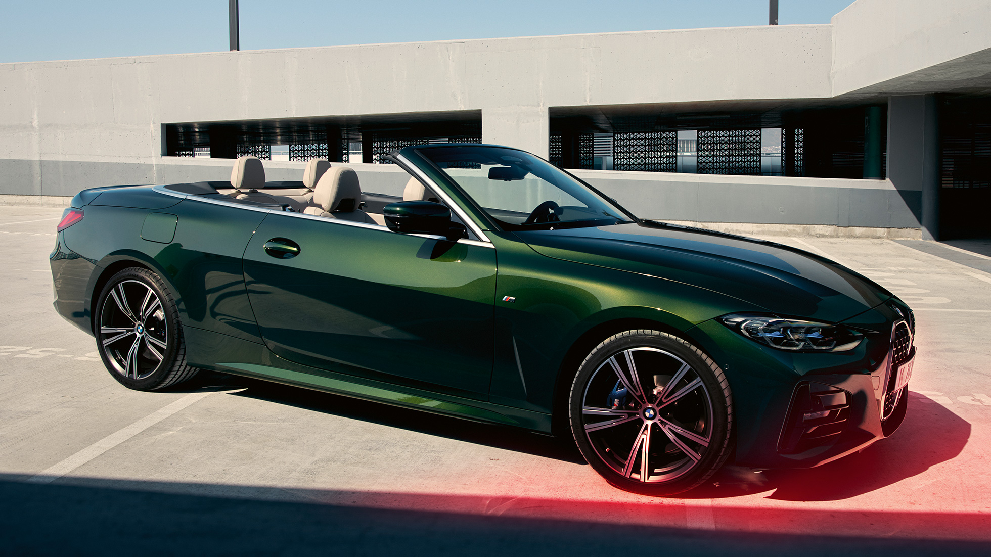 Driekwart vooraanzicht BMW 4 Serie Cabrio G23 met man BMW 4 Serie Cabrio G23 Sanremo Green metallic driekwart vooraanzicht met man