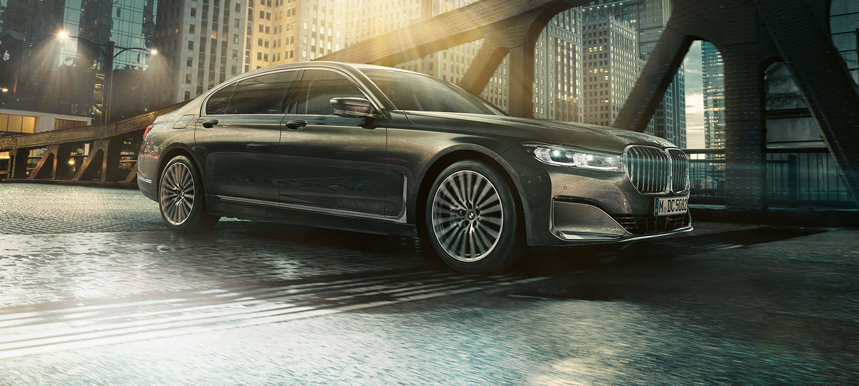 BMW 7 Serie Sedan zijaanzicht De BMW 7 Serie Sedan in zijaanzicht met geopend portier voor verlicht hotel