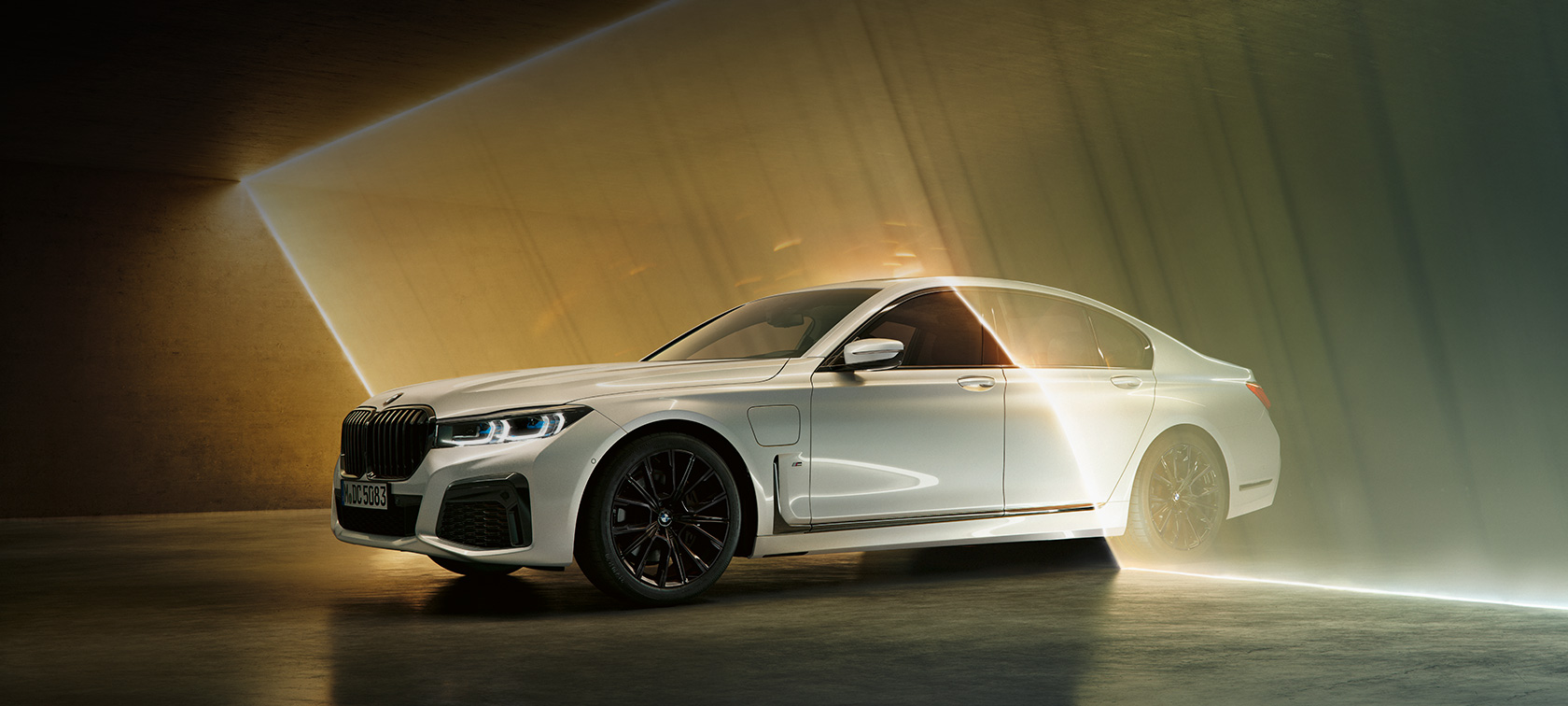 BMW 7 Serie Sedan, wit, driekwart vooraanzicht BMW 7 Serie Sedan: driekwart vooraanzicht van witte BMW omgeven door lichtstralen