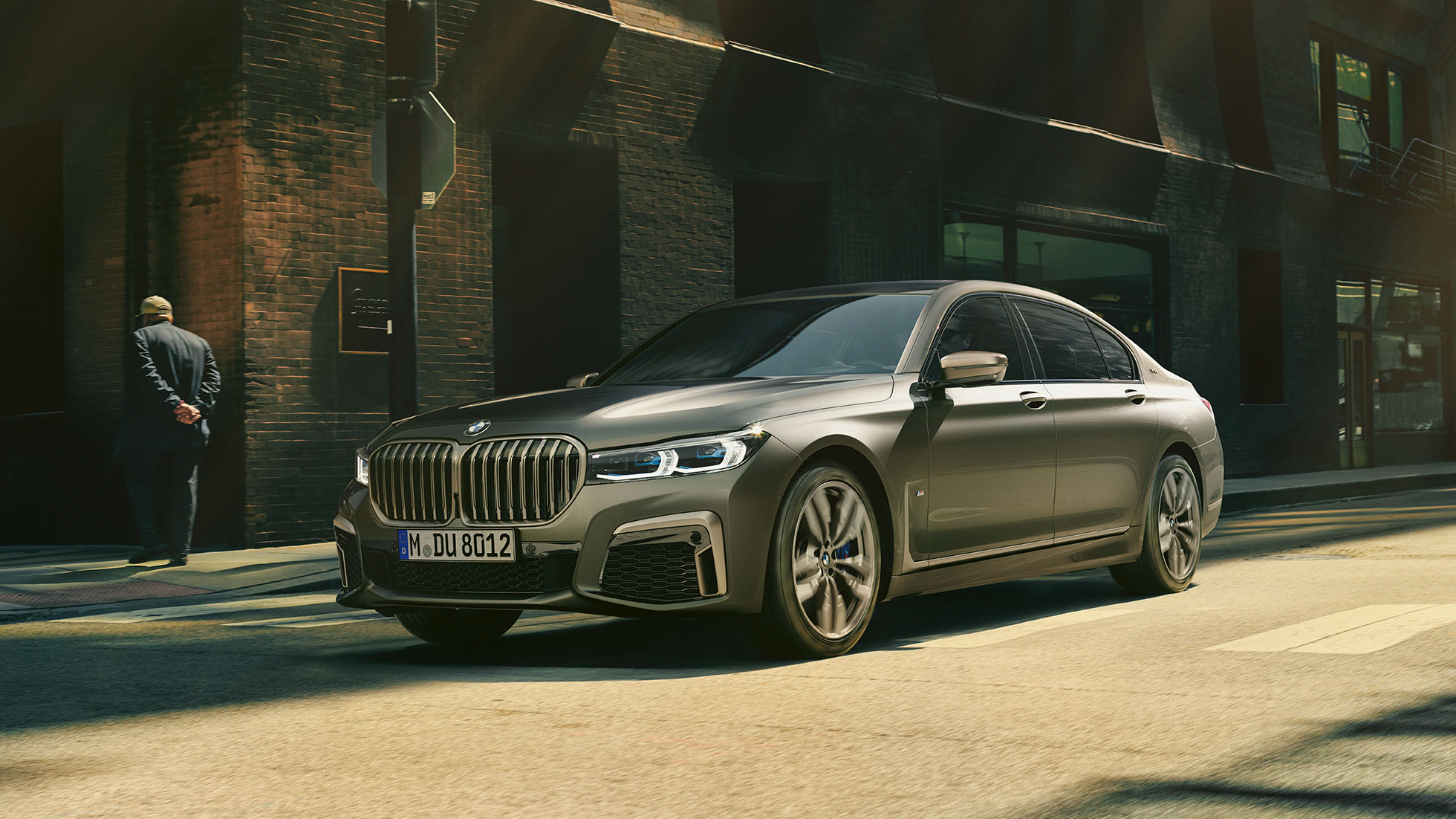 BMW M760Li xDrive in een stedelijke omgeving Het vooraanzicht van de BMW M760Li xDrive voor wolkenkrabbers in een stedelijke omgeving