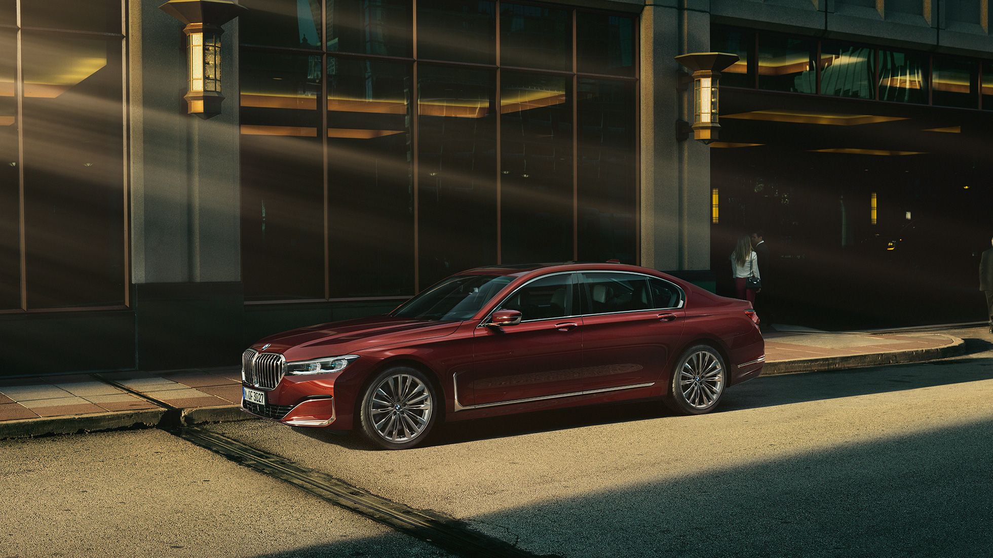 BMW Invidivual 7 Serie Sedan, zijaanzicht Het zijaanzicht van de rode BMW Individual 7 Serie Sedan in stedelijke omgeving