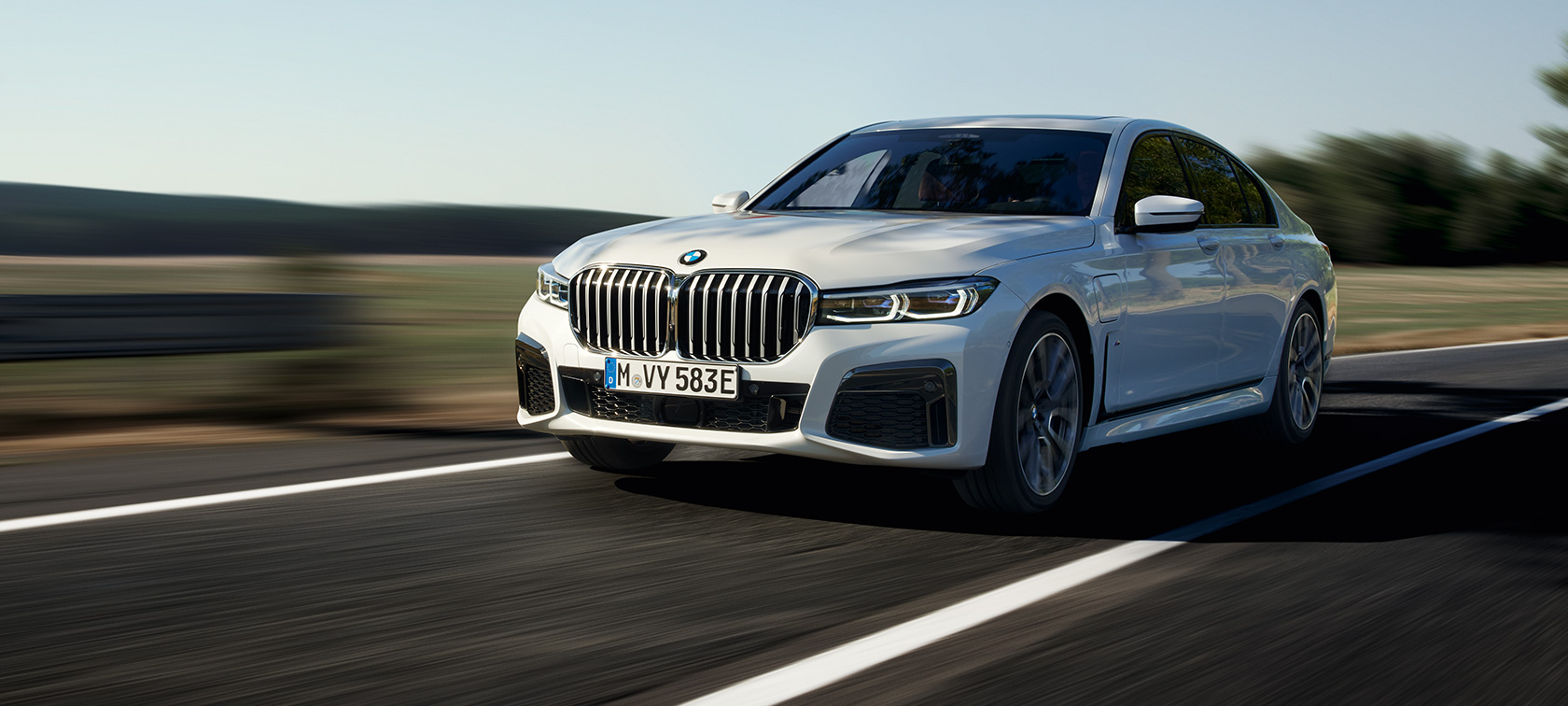 BMW 745e Sedan Plug-in Hybride G11 G12 Mineralweiß metallic driekwart vooraanzicht BMW 745e Sedan Plug-in Hybride G11 G12 Mineralweiß metallic driekwart vooraanzicht rijdend