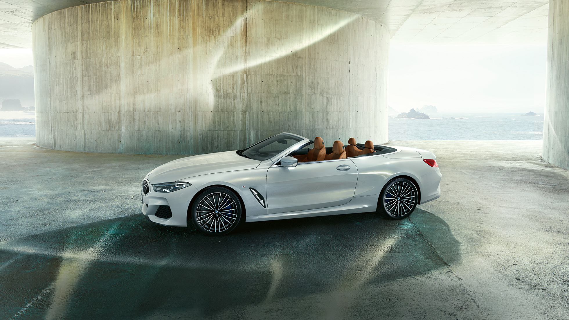 BMW M850i xDrive in Mineralweiß metallic, zijaanzicht met geopende softtop. BMW M850i xDrive in Mineralweiß metallic, zijaanzicht met geopende softtop.