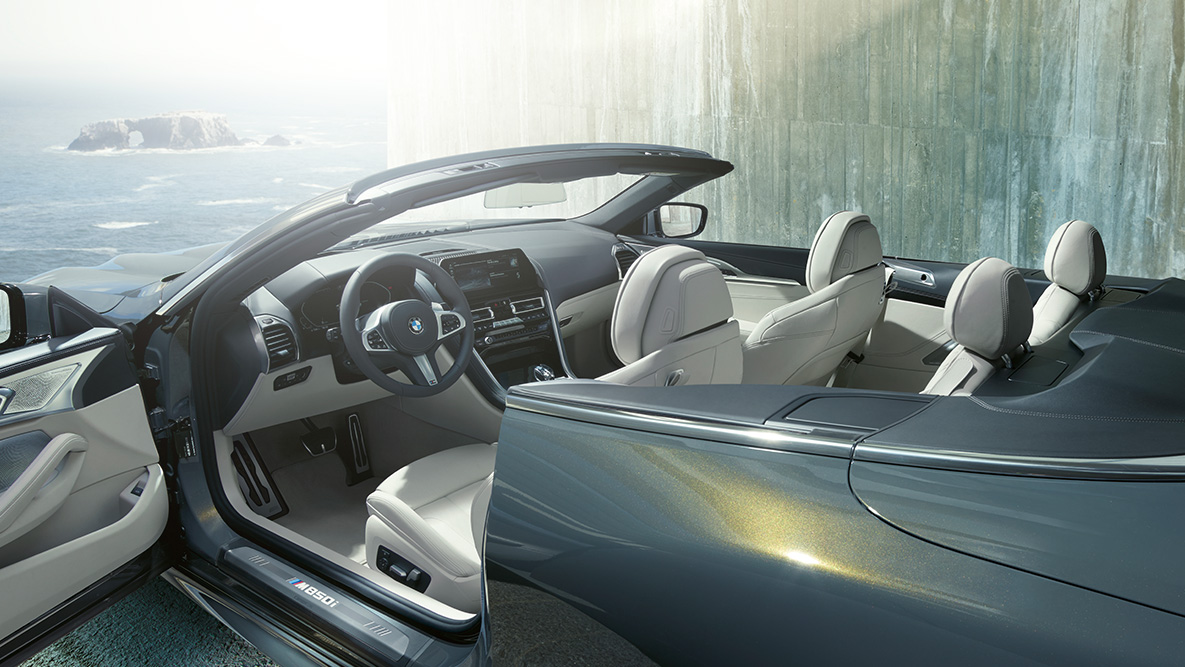 BMW M850i xDrive in Dravitgrau metallic, interieur, softtop en portier geopend. BMW M850i xDrive in Dravitgrau metallic, interieur, softtop en portier geopend.
