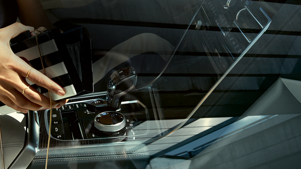 BMW M850i xDrive interieur, glasapplicatie CraftedClarity, vrouw met geopende handtas. BMW M850i xDrive interieur, glasapplicatie CraftedClarity, vrouw met geopende handtas.