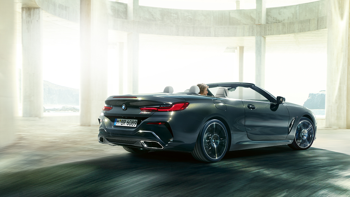 BMW M850i xDrive met geopende softtop, rijdend, zijaanzicht. BMW M850i xDrive met geopende softtop, rijdend, zijaanzicht.
