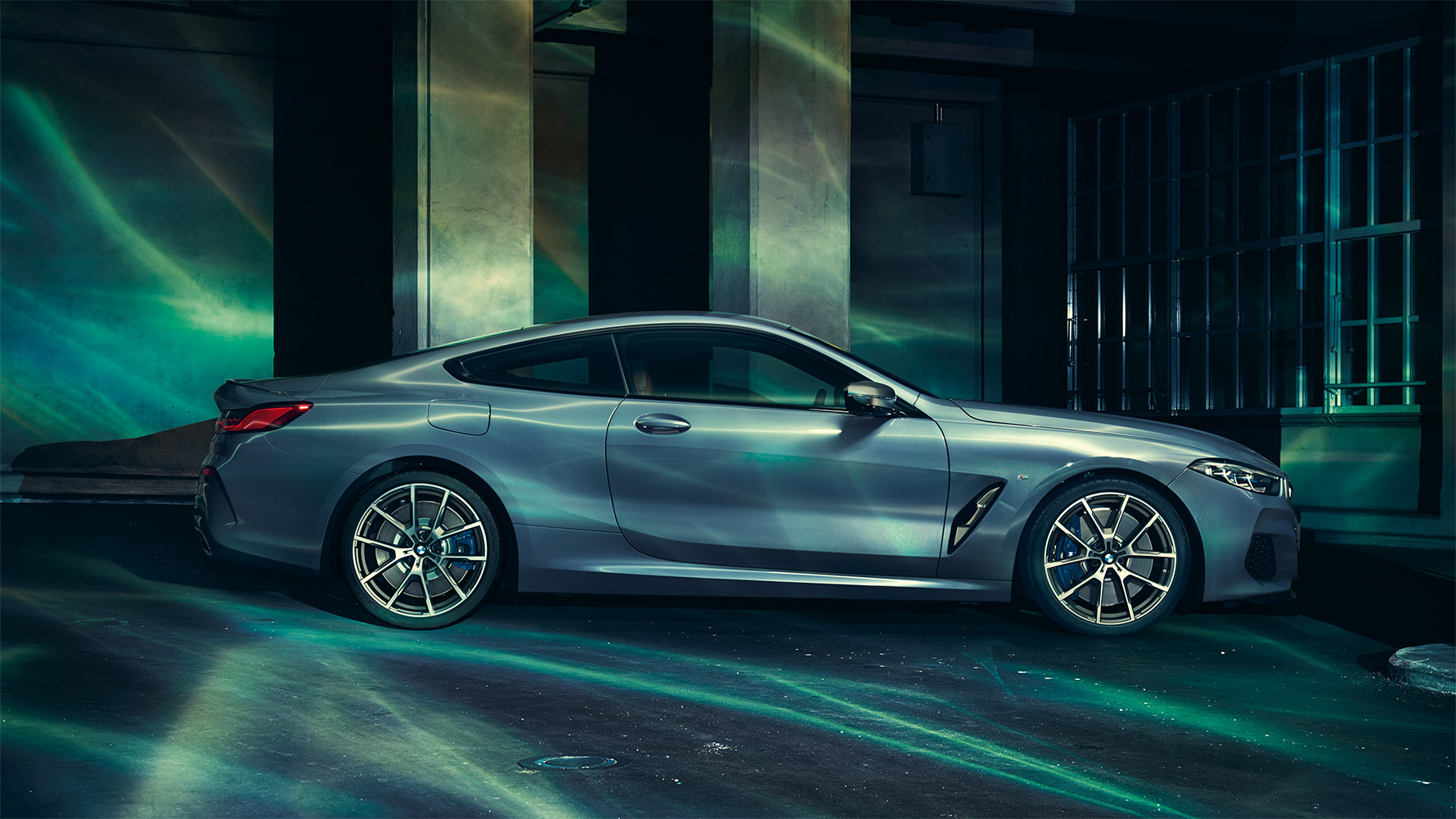 BMW 8 Serie, zijaanzicht Stilstaande BMW 8 Serie Coupé van opzij gezien met op de achtergrond een skyline.