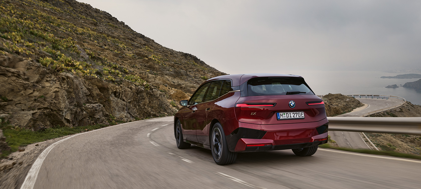 BMW iX i20 elektrische SUV BMW iX xDrive50 rijdend BMW iX i20 elektrische SUV BMW iX xDrive50 Aventurinrot achteraanzicht rijdend