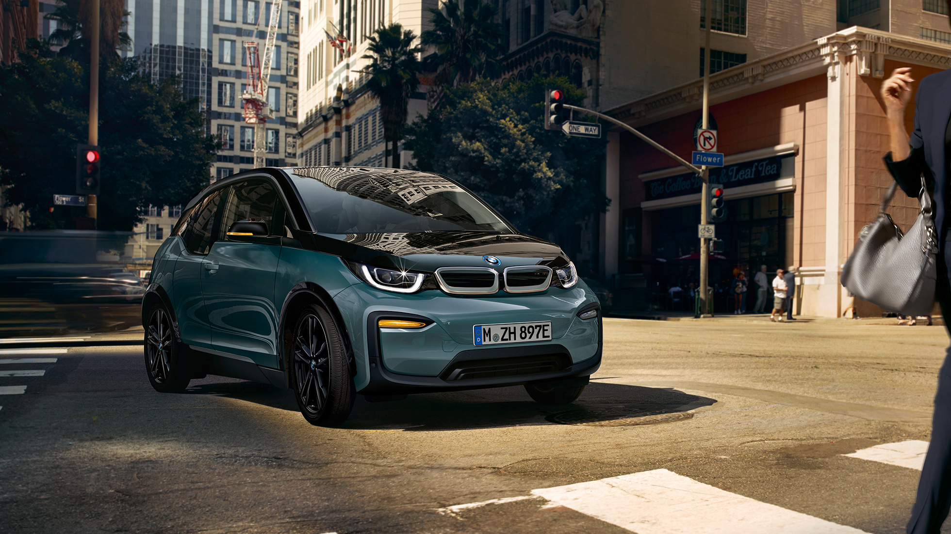 BMW i3 driekwart vooraanzicht rijdend BMW i3 Jucarobeige met accenten in Frozen Grey metallic driekwart vooraanzicht rijdend