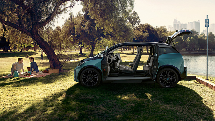 BMW i3 2018 in park BMW i3 I01 2018 Jucarobeige met accenten in Frozen Grey metallic zijaanzicht met geopende portieren in park