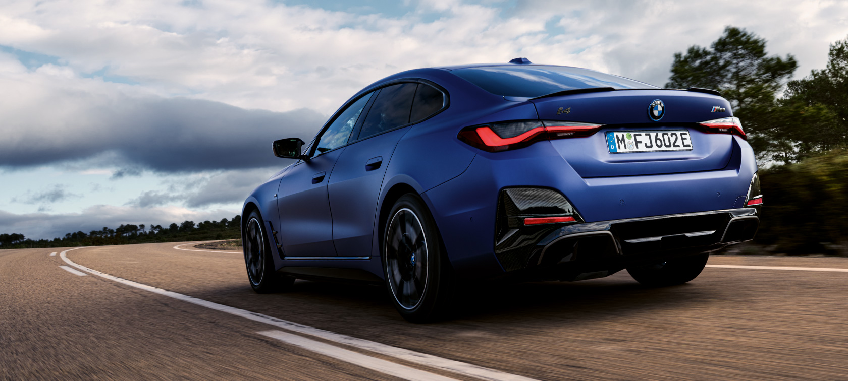 BMW i4 M50 G26 driekwart achteraanzicht BMW i4 M50 G26, BMW Individual Frozen Portimao Blau metallic driekwart achteraanzicht rijdend