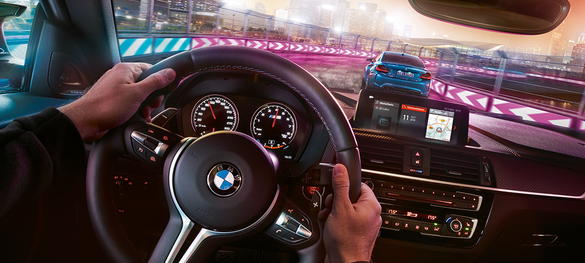 BMW M2 Competition cockpit Twee racende BMW’s M2 Competition bij nacht, gezien vanuit de cockpit.