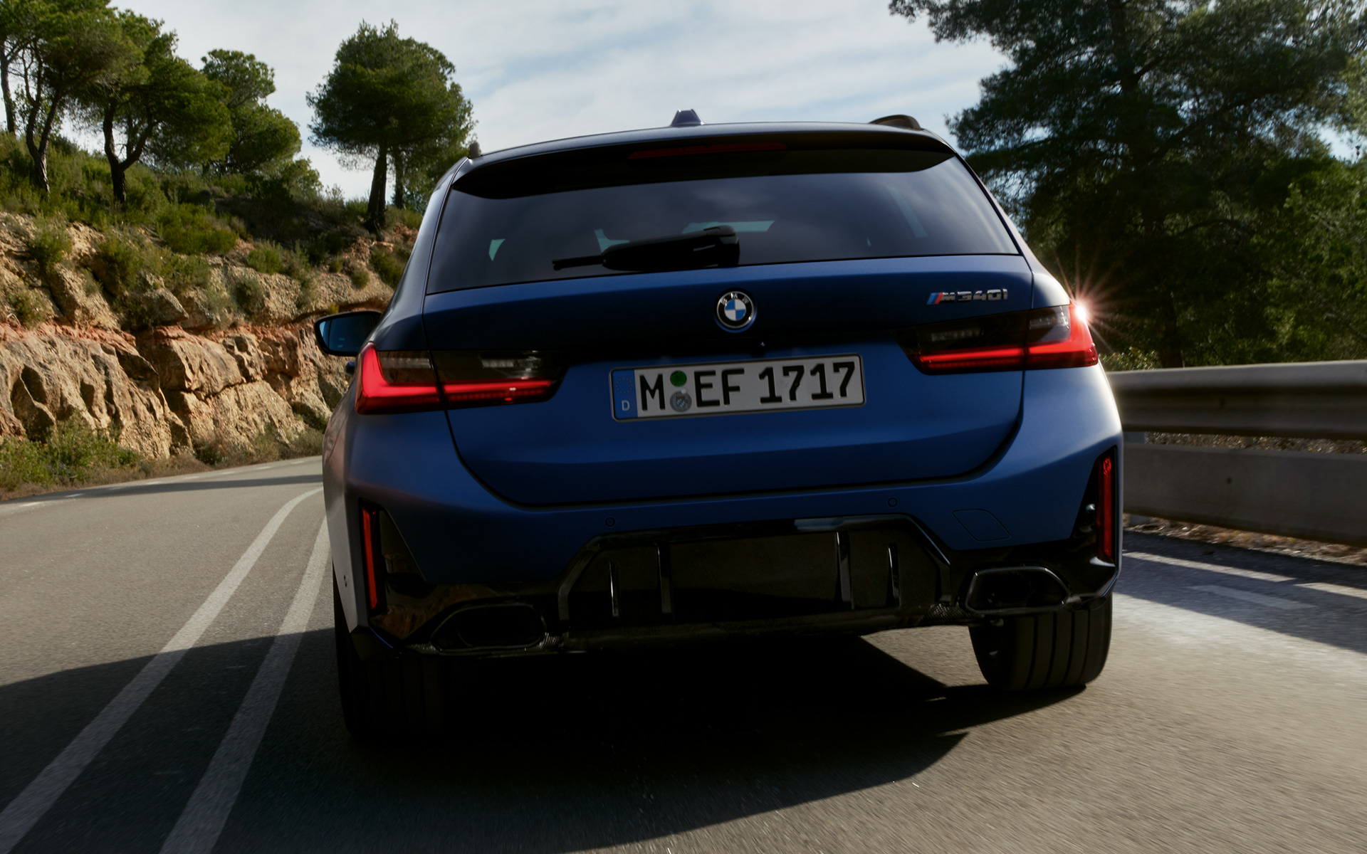BMW M340i xDrive Touring G21 Frozen Tanzanite Blue achteraanzicht rijdend