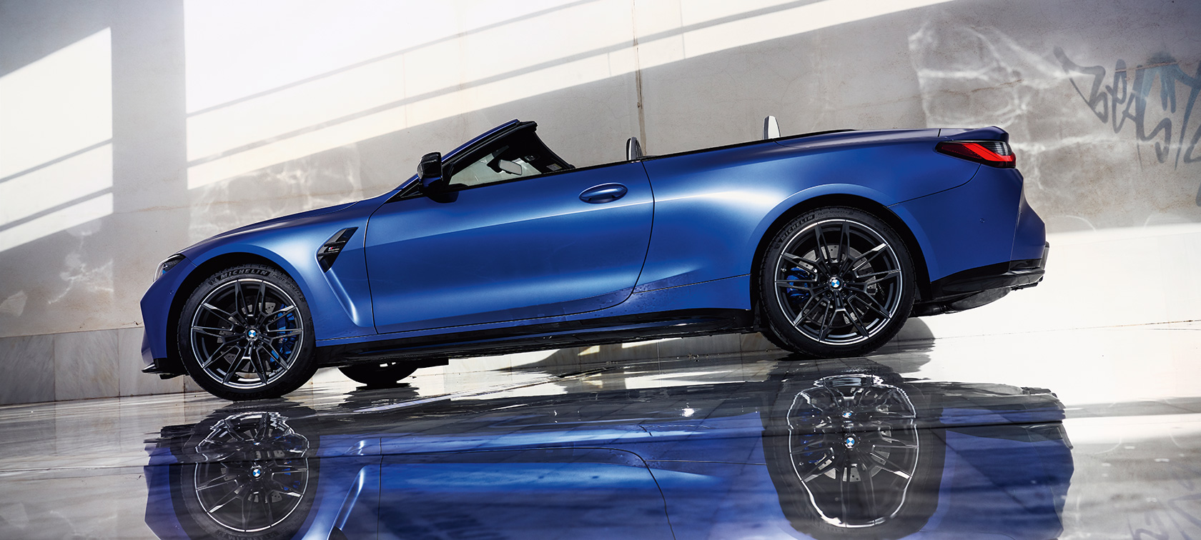 BMW M4 Competition Cabrio met M xDrive G83 driekwart vooraanzicht rijdend BMW M4 Competition Cabrio met M xDrive G83 BMW Individual Frozen Portimao Blau metallic driekwart vooraanzicht, rijdend