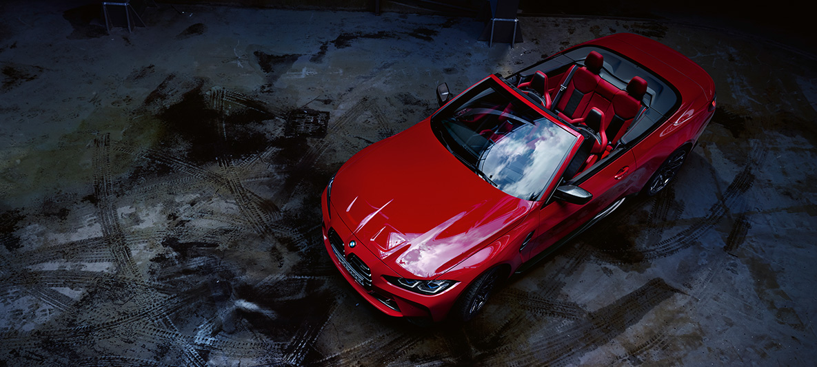 BMW Individual Imolarot metallic BMW M4 Competition Cabrio met M xDrive G83 BMW M4 Competition Cabrio met M xDrive G83 BMW Individual Imolarot metallic driekwart vooraanzicht van boven open stoffen cabriokap