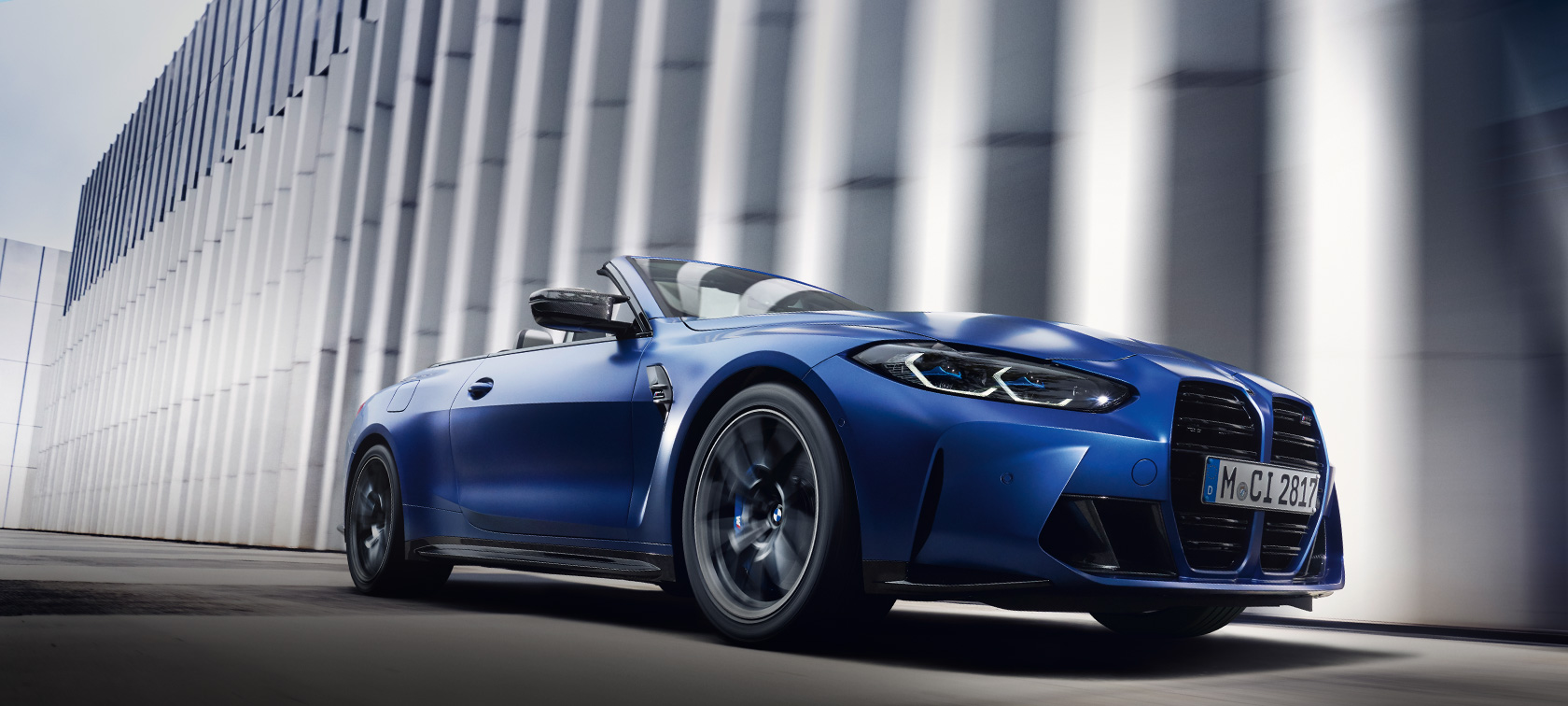 BMW M4 Competition Cabrio met M xDrive G83 BMW Individual Frozen Portimao Blau metallic zijaanzicht staand laag perspectief