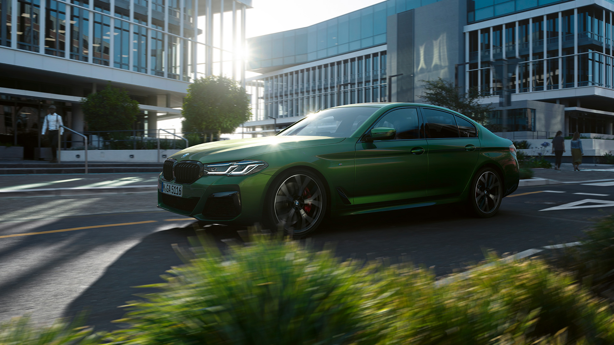 BMW M550i xDrive Sedan G30 LCI zijaanzicht rijdend BMW M550i xDrive Sedan G30 LCI BMW Individual Verde Ermes metallic zijaanzicht rijdend