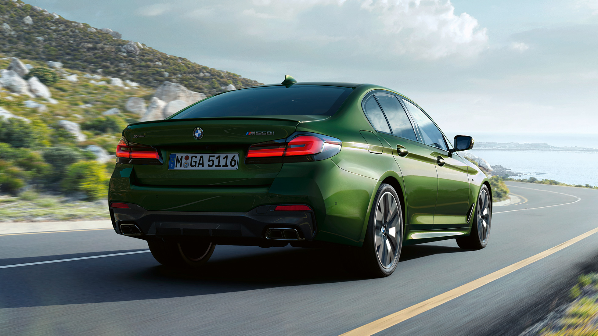 BMW M550i xDrive Sedan G30 LCI achteraanzicht BMW M550i xDrive Sedan G30 LCI BMW Individual Verde Ermes metallic achteraanzicht rijdend