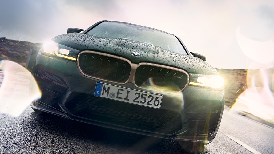 BMW M5 CS F90 Frozen Deep Green metallic vooraanzicht met ingeschakelde koplampen