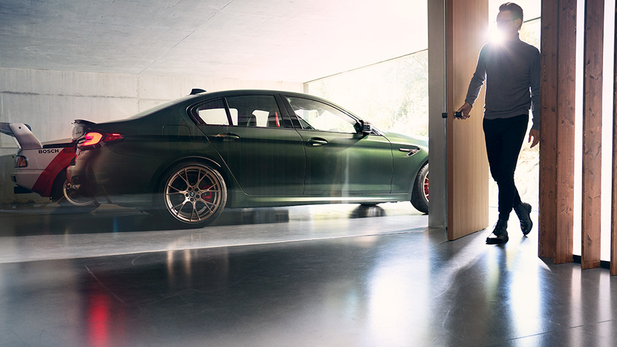 BMW M5 CS F90 Frozen Deep Green metallic zijaanzicht in garage
