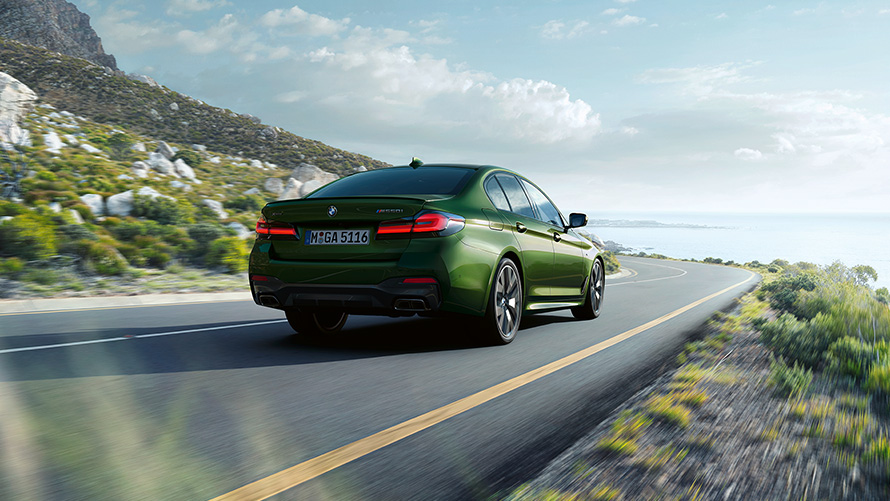 BMW M550i xDrive Sedan G30 LCI BMW Individual Verde Ermes metallic driekwart achteraanzicht rijdend