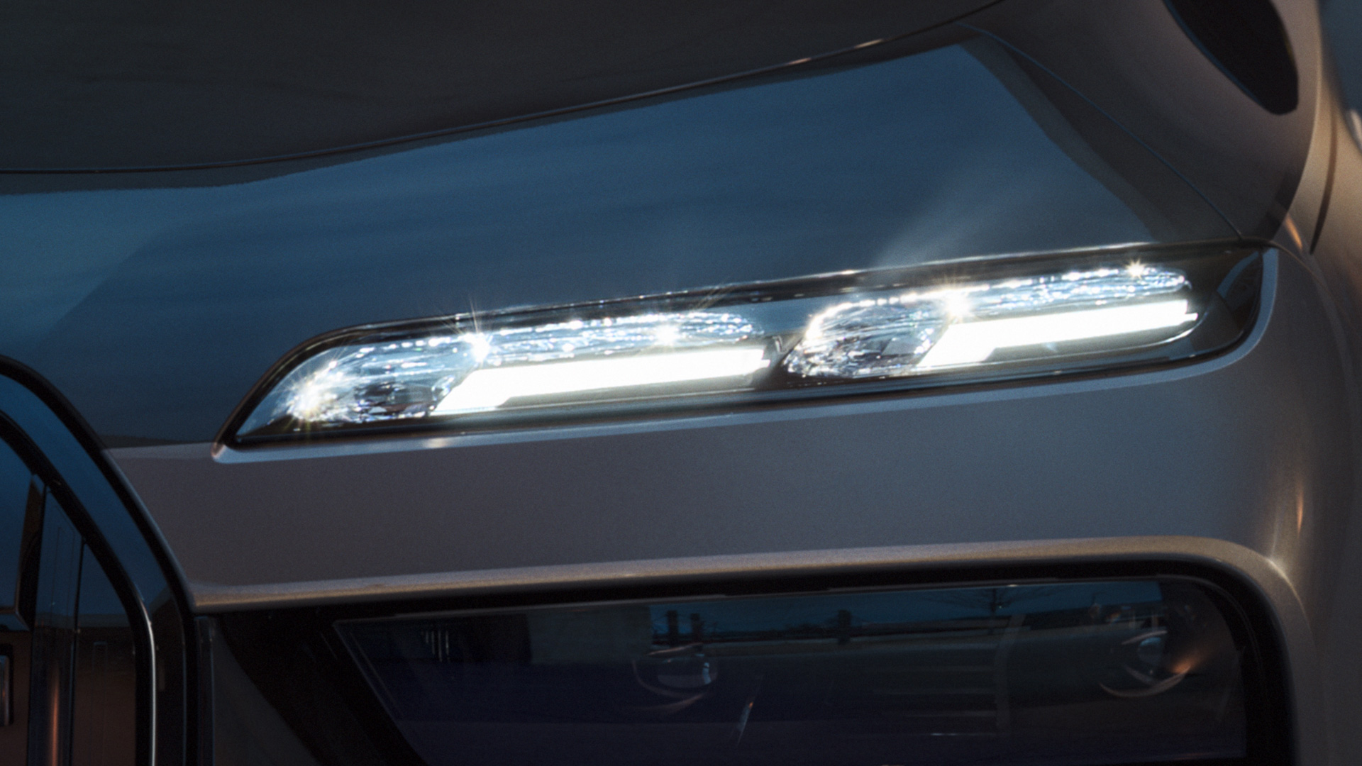 BMW kristalkoplampen Iconic Glow BMW M760e xDrive Sedan G70 BMW Individual two-tone carrosseriekleur Saphirschwarz metallic BMW Individual Dravitgrau metallic close-up met ingeschakelde verlichting