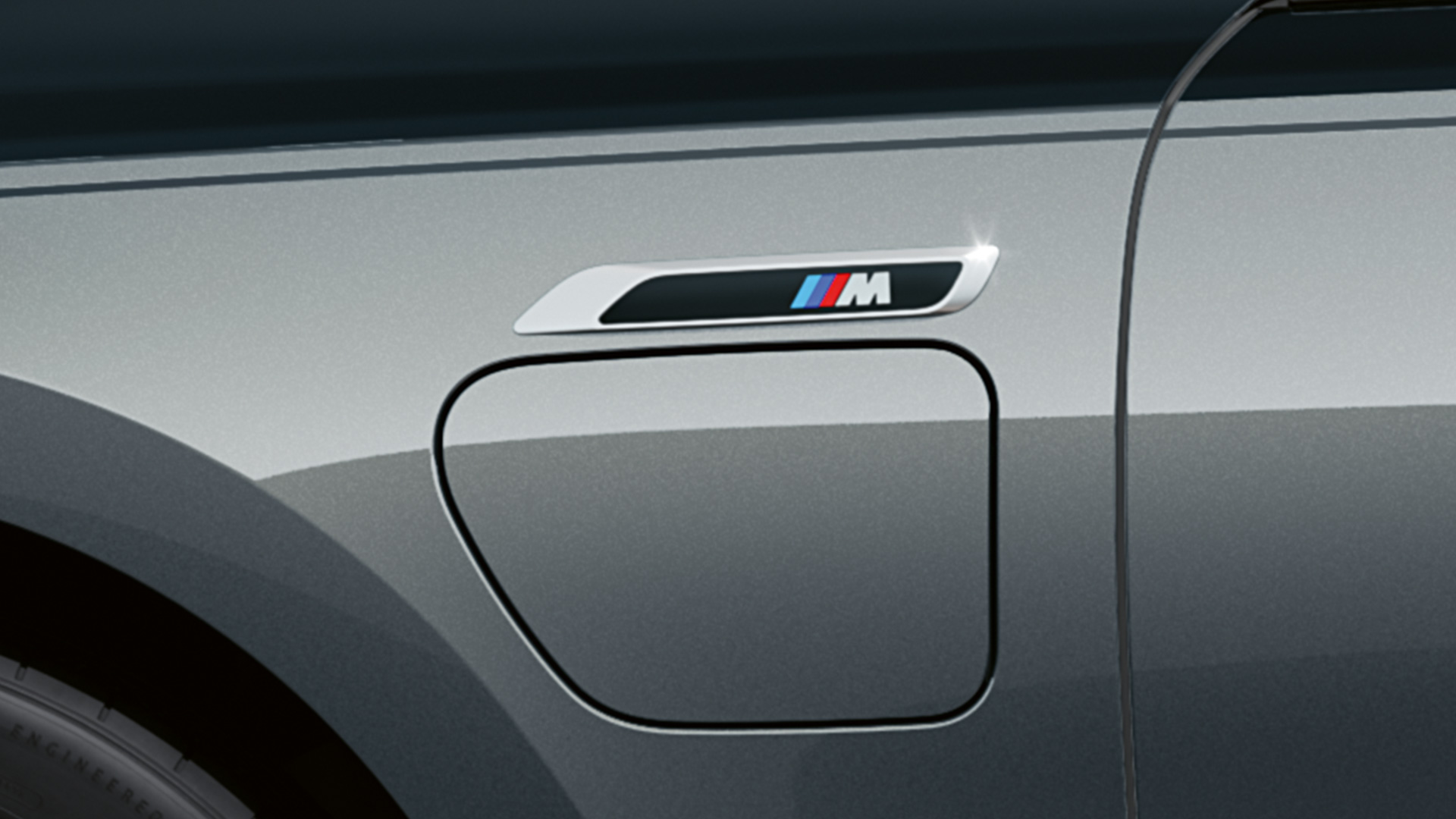 M embleem BMW M760e xDrive Sedan G70 M Performance Pack BMW Individual two-tone carrosseriekleur Saphirschwarz metallic BMW Individual Dravitgrau metallic close-up zijaanzicht