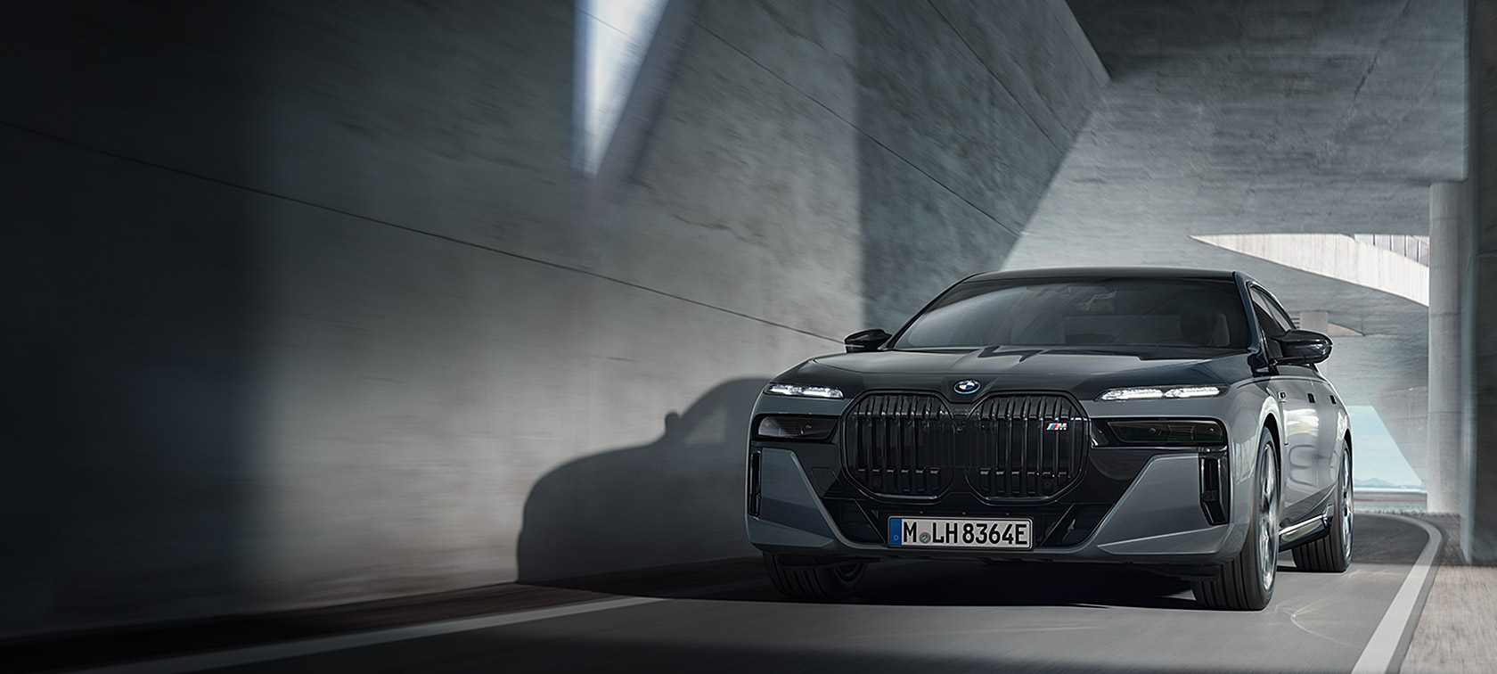 BMW M760e xDrive Sedan G70 M Performance Pack BMW Individual two-tone carrosseriekleur Saphirschwarz metallic BMW Individual Dravitgrau metallic driekwart vooraanzicht rijdend