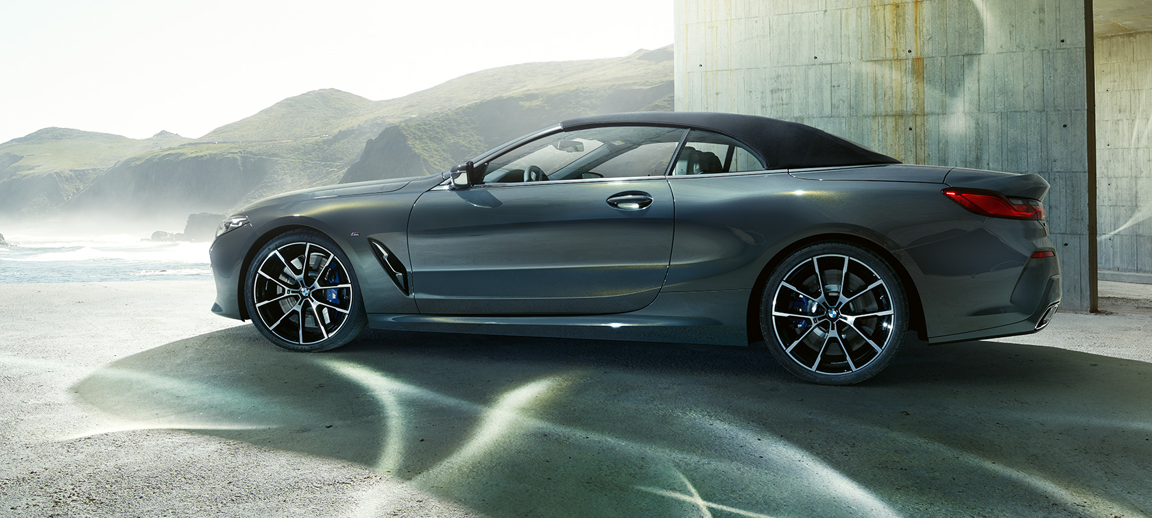 BMW M850i xDrive Cabrio, zijaanzicht. BMW M850i xDrive Cabrio in Dravit Grau metallic met gesloten softtop, zijaanzicht.