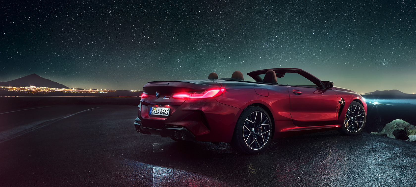 BMW M8 Competition Cabrio, driekwart achteraanzicht F91. BMW M8 Competition Cabrio in Motegi Rot metallic met geopende softtop, driekwart achteraanzicht stilstaand F91.