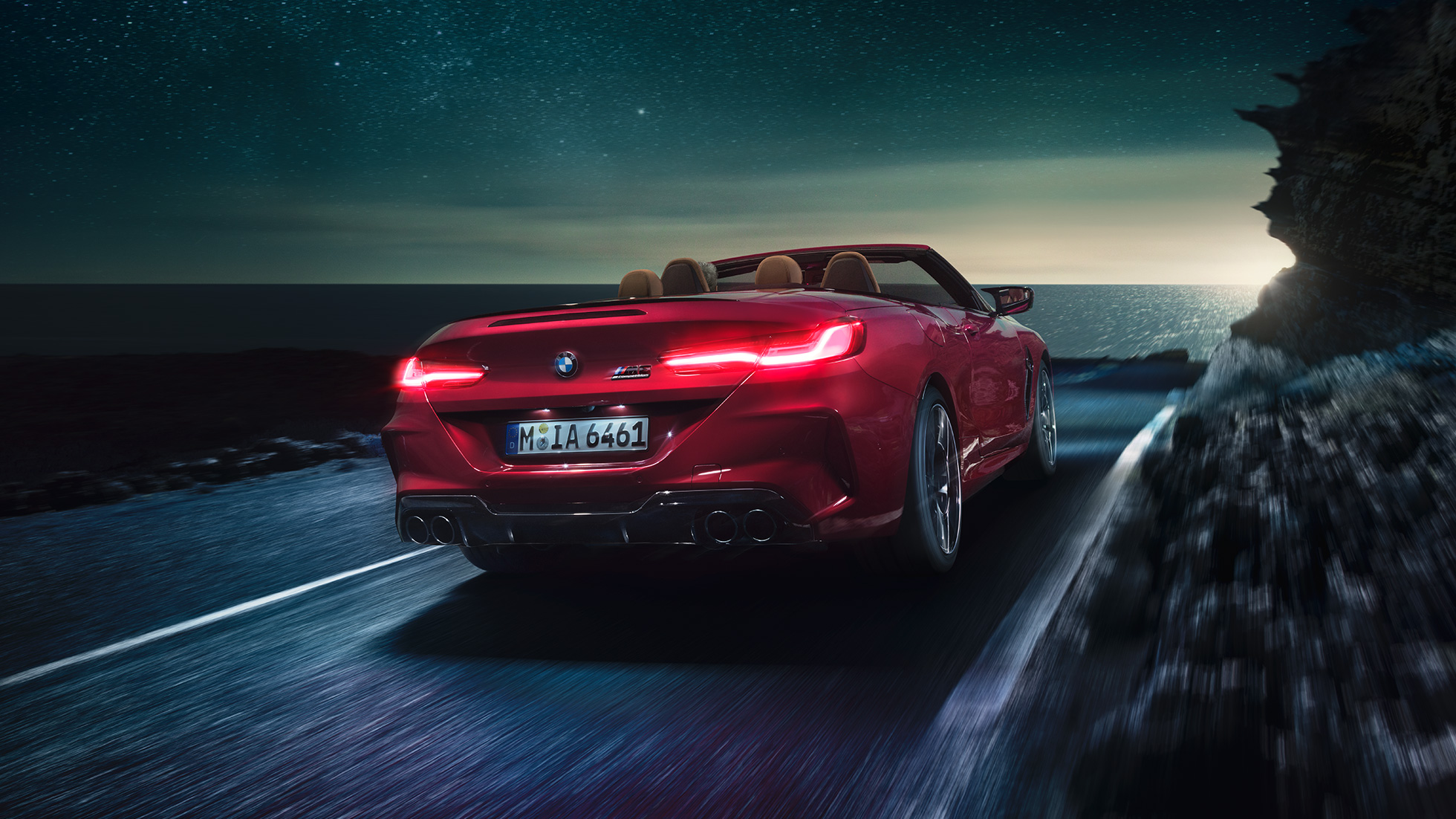 BMW M8 Competition Cabrio, driekwart achterzijde. BMW M8 Competition Cabrio in Motegi Rot metallic, geopende softtop, driekwart achterzijde, rijdend.