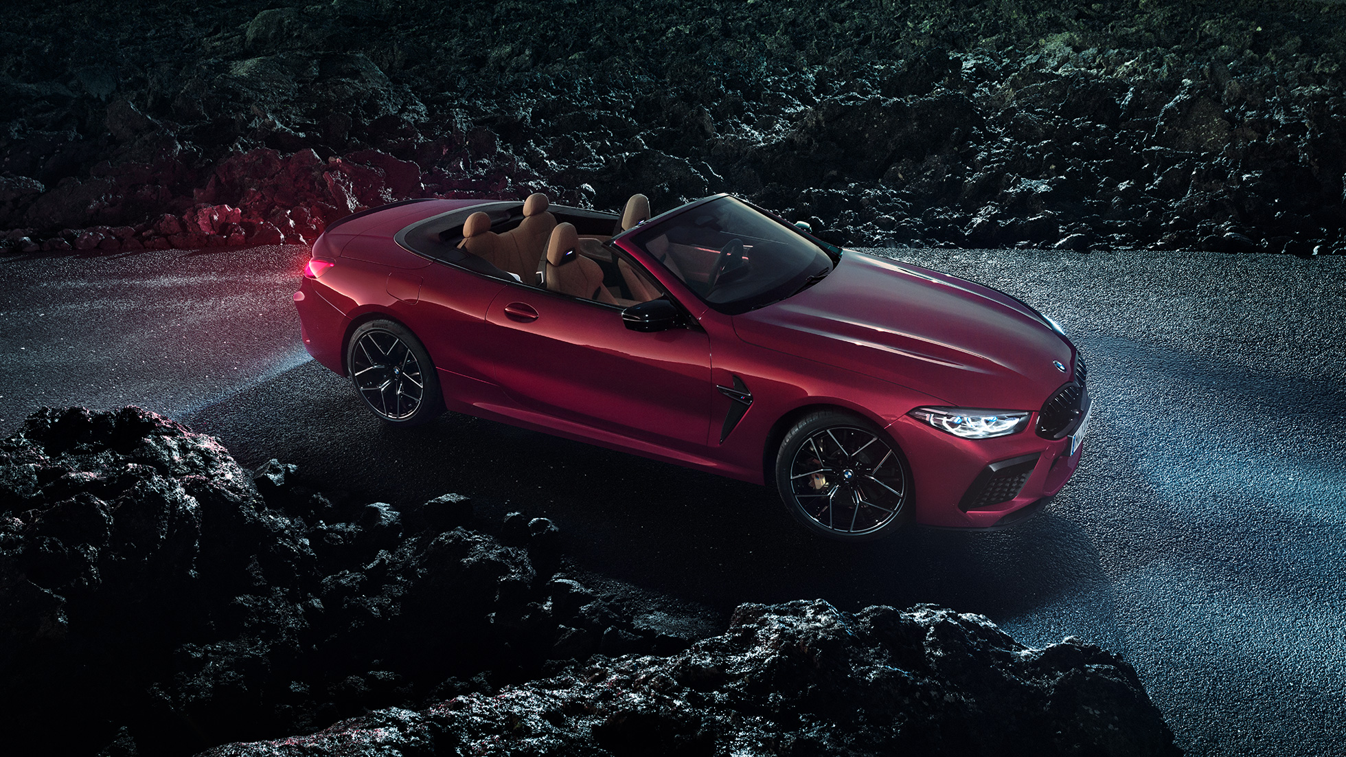 BMW M8 Competiton Cabrio, driekwart zijaanzicht. BMW M8 Competition Cabrio in Motegi Rot metallic, geopende softtop, driekwart zijaanzicht, stilstaand.