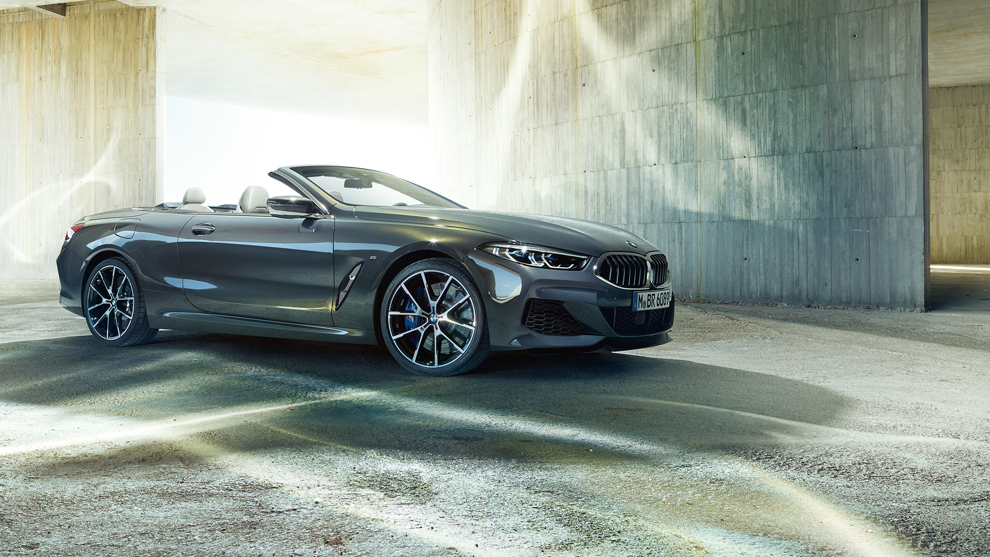 BMW M850i xDrive Cabrio, driekwart zijaanzicht. BMW M850i xDrive Cabrio in Dravitgrau metallic met open softtop, driekwart zijaanzicht, stilstaand
