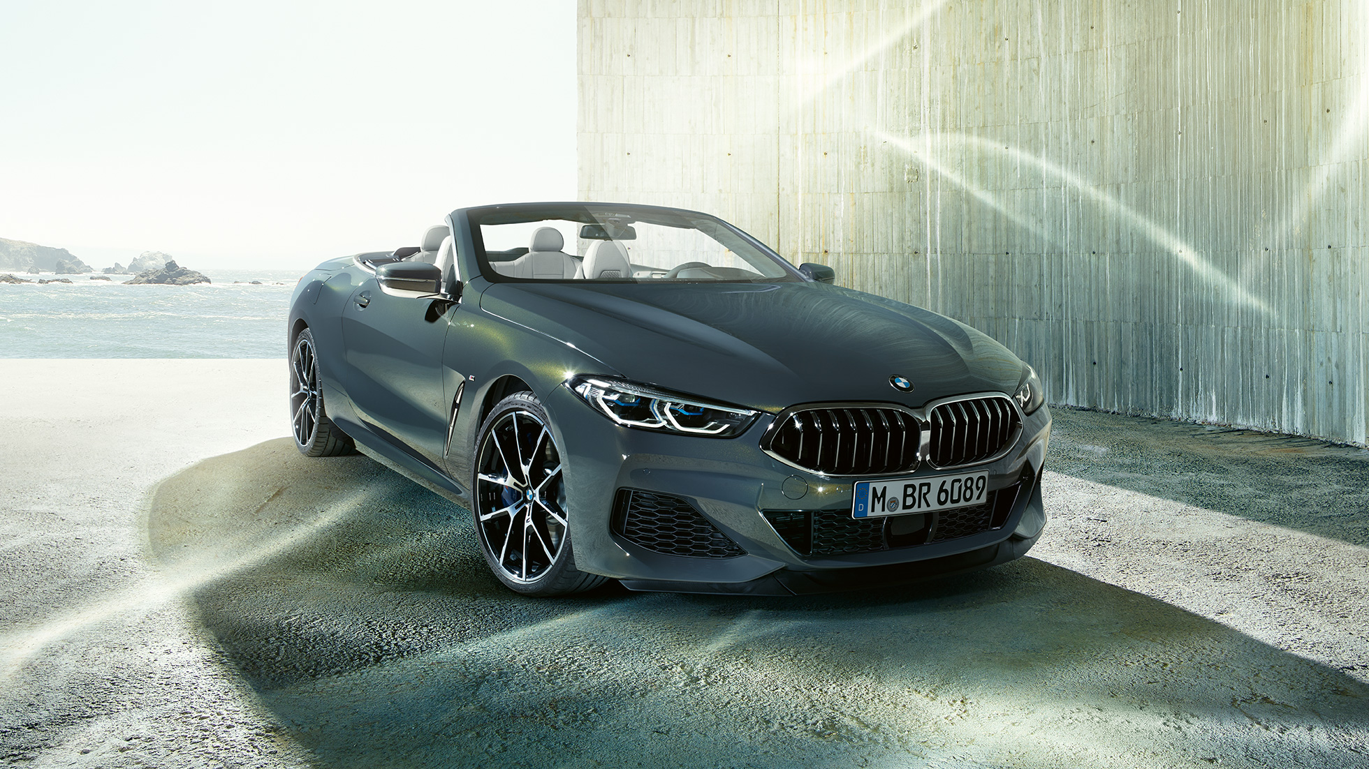 BMW M850i xDrive Cabrio, driekwart vooraanzicht. BMW M850i xDrive Cabrio in Dravitgrau metallic met open softtop, driekwart vooraanzicht, stilstaand