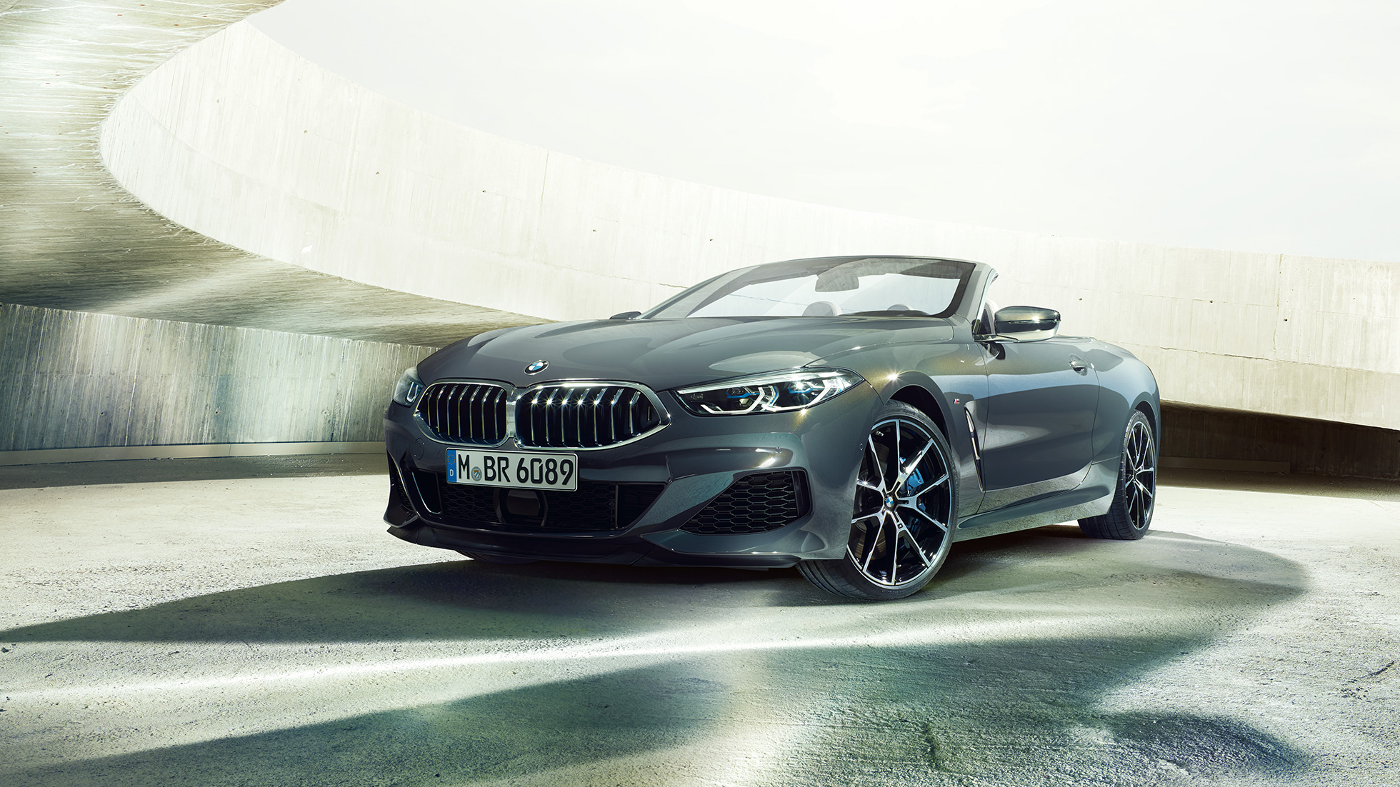 BMW M850i xDrive Cabrio, driekwart vooraanzicht. BMW M850i xDrive Cabrio in Dravitgrau metallic, met open softtop, driekwart vooraanzicht, stilstaand