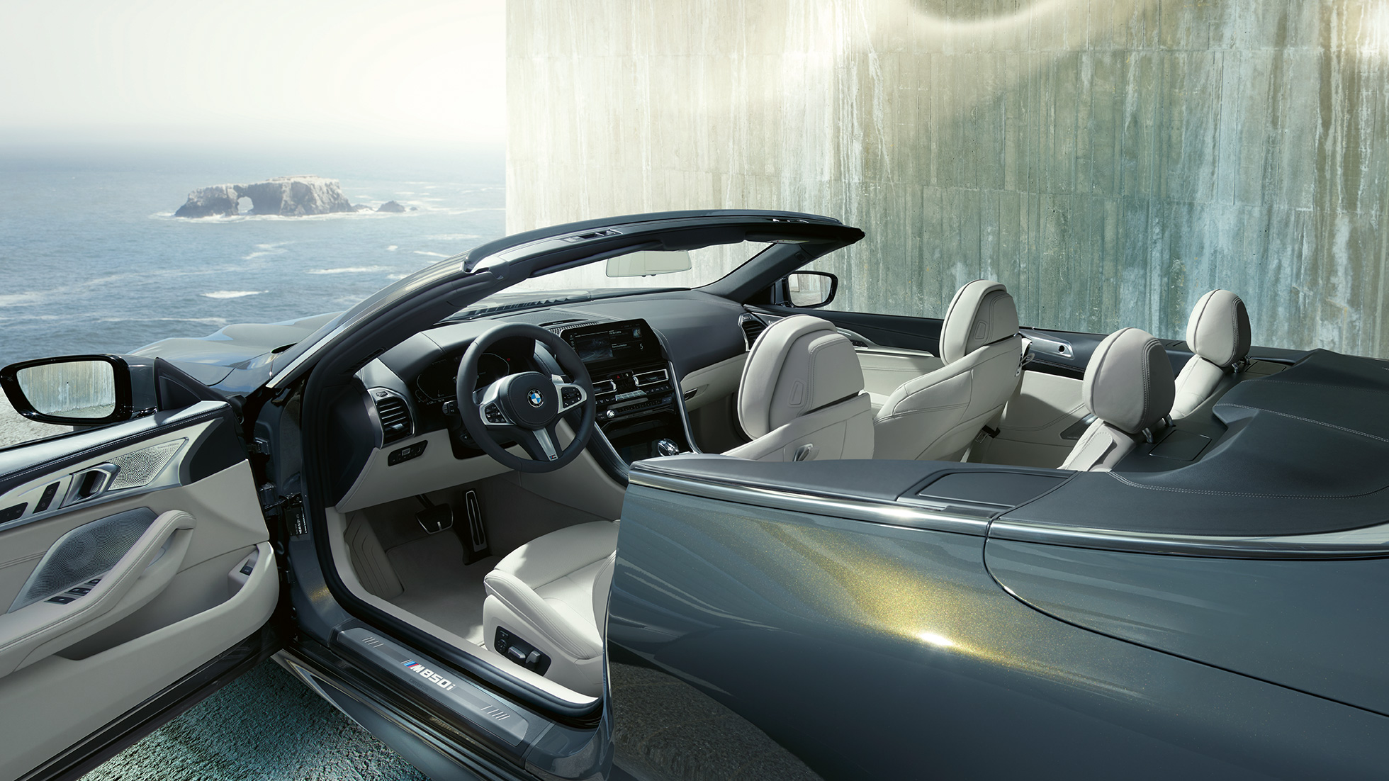 BMW M850i xDrive Cabrio, interieur. BMW M850i xDrive Cabrio in Dravitgrau metallic met open softtop, interieur met M stuurwiel met leder bekleed en BMW Individual lederuitrusting 'Merino' Elfenbeinweiß.