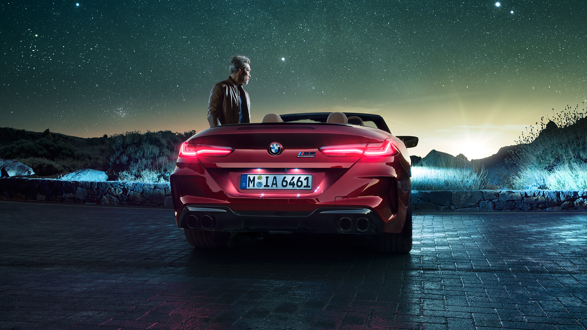 BMW M8 Competition Cabrio, achteraanzicht. BMW M8 Competition Cabrio in Motegi Rot metallic, open dak, achteraanzicht