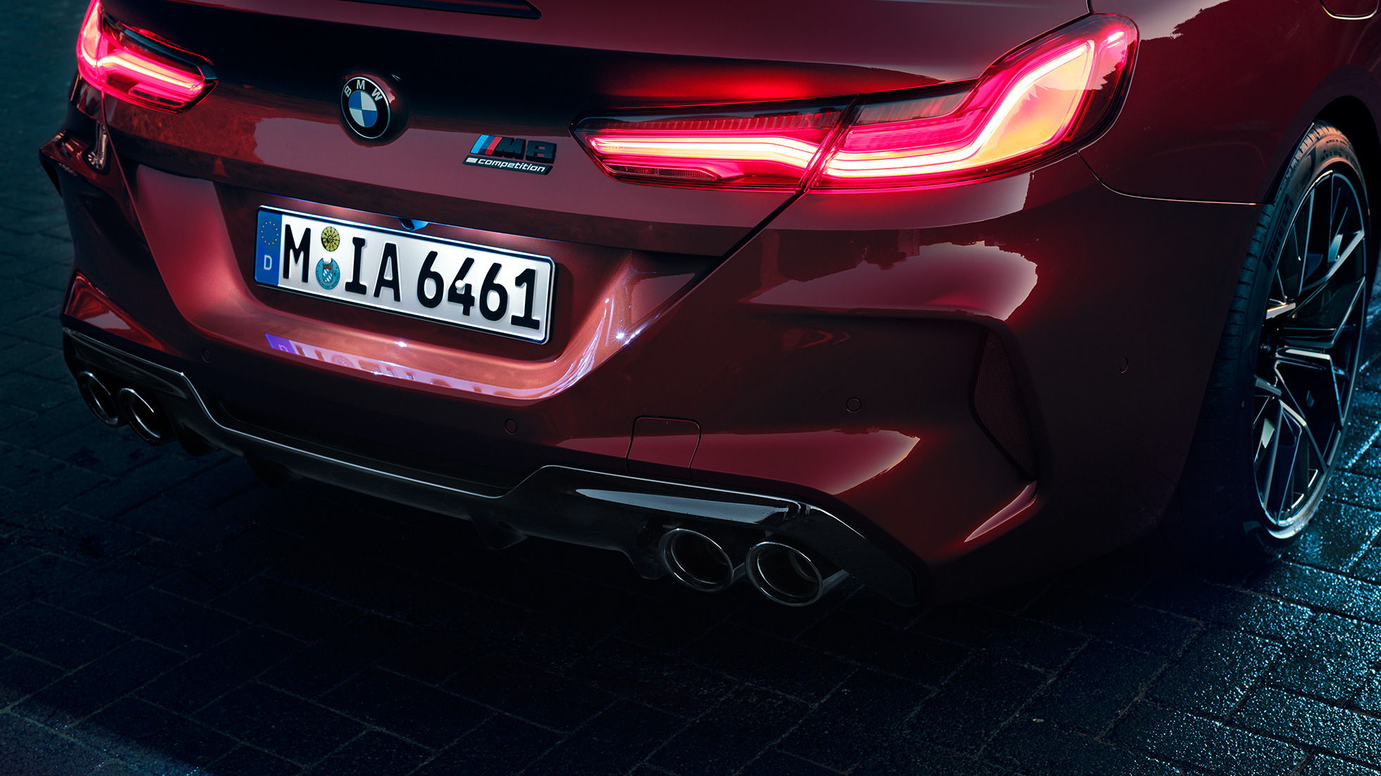 BMW M8 Competition Cabrio, close-up achterzijde. BMW M8 Competition Cabrio in Motegi Rot metallic, close-up LED-achterlichten en M8 Competition badge.
