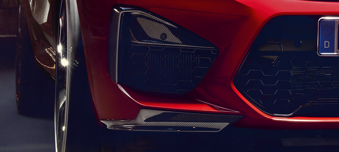 BMW X4 M Competition, elementen van de buitenste luchtinlaten en aeroblades in Carbon. BMW X4 M Competition in Toronto Rot metallic, exterieur, M Carbon exterieurpakket, elementen van de buitenste luchtinlaten en aeroblades in Carbon.