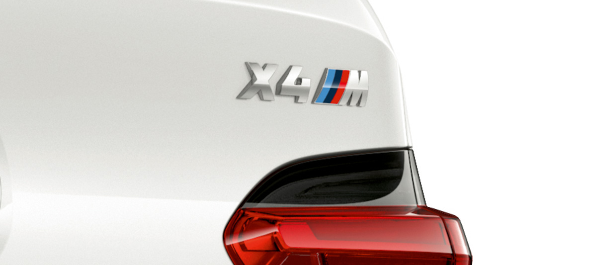 BMW X4 M, modelaanduiding. BMW X4 M in Alpinweiß, exterieur, close-up achterzijde met modelaanduiding.