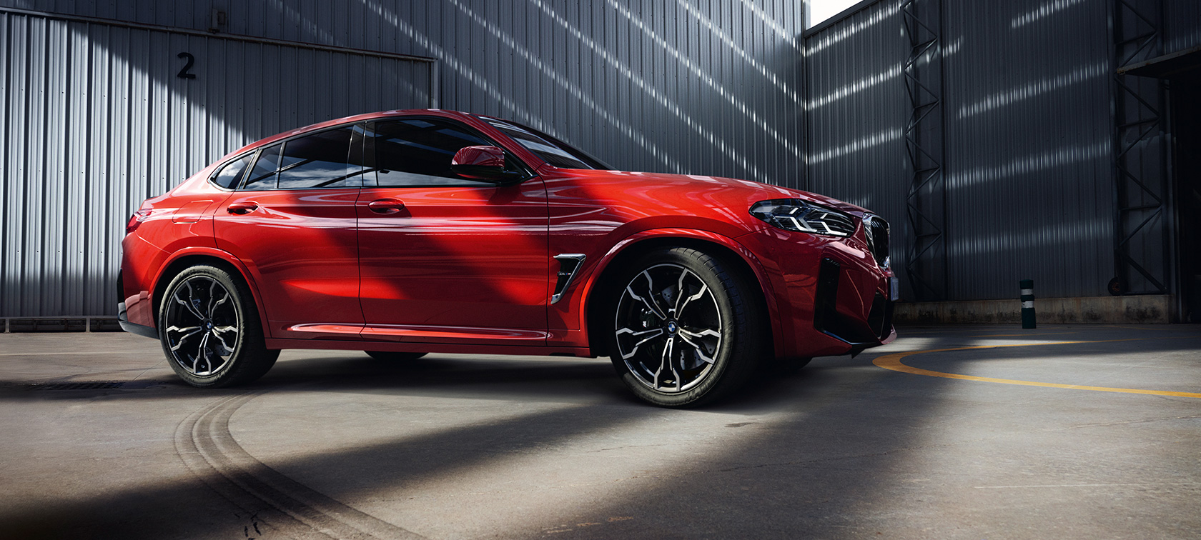 Driekwart vooraanzicht BMW X4 M SUV F98 LCI facelift BMW X4 M SUV F98 LCI facelift Toronto Rot metallic driekwart vooraanzicht in fabriekshal