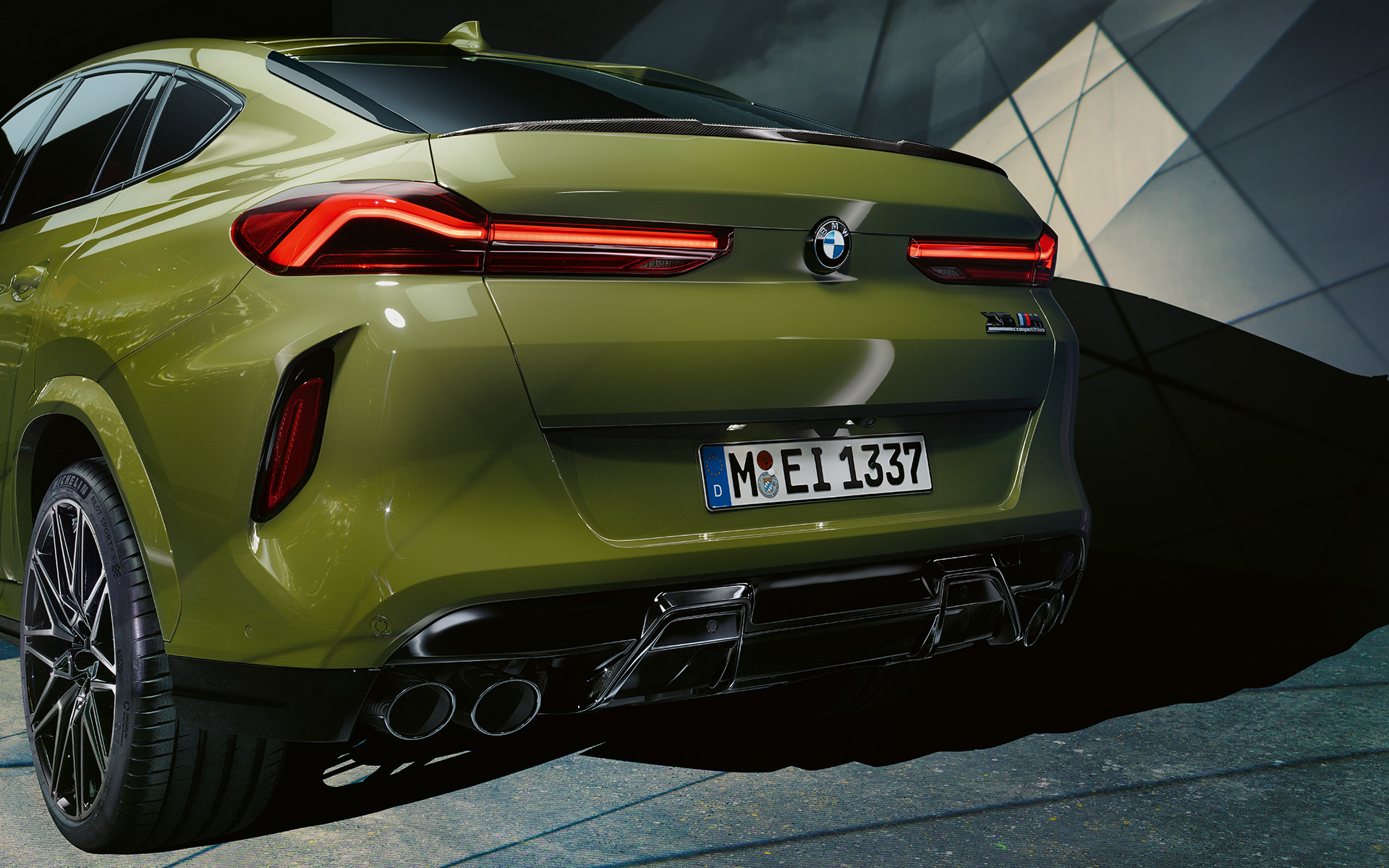 BMW X6 M Competition F96 driekwart achteraanzicht BMW X6 M Competition F96 SUV met M Sportuitlaatsysteem BMW Individual speciale carrosseriekleur Urban Green SUV close-up achterzijde