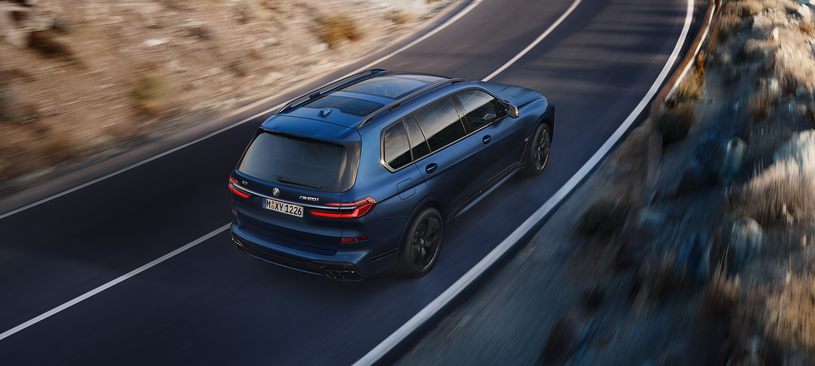 BMW X7 M60i xDrive G07 LCI Frozen Marina Bay Blue driekwart achteraanzicht bovenaanzicht rijdend BMW X7 M60i xDrive G07 LCI Frozen Marina Bay Blue driekwart achteraanzicht bovenaanzicht rijdend