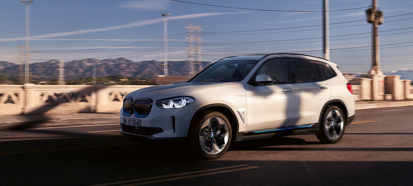 BMW iX3 G08 driekwart vooraanzicht rijdend BMW iX3 G08 Mineralweiß metallic driekwart vooraanzicht rijdend