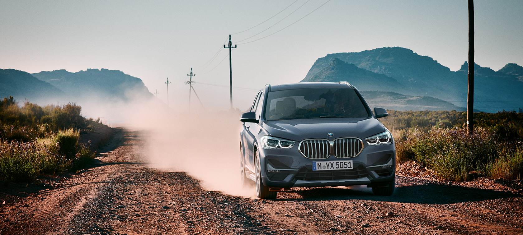 BMW X1, driekwart achteraanzicht. BMW X1, driekwart achteraanzicht rijdend.
